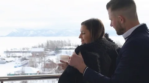 Young couple drinking coffee on the balcony,winter Stock Footage 73851773