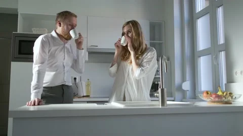 Young couple drinking coffee for breakfast in the kitchen before work Stock-Footage 142960317