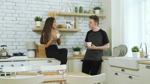 Young Couple Drinking Hot Coffee in Kitchen Stock Footage 134169375