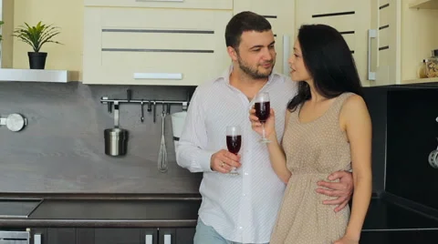 Young couple drinking red wine in the kitchen at home Stock Footage 63413297