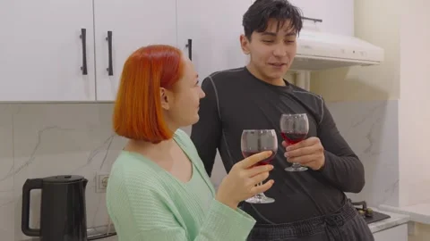 Young couple drinking red wine in kitchen Stock Footage 330526557
