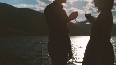 Young couple drinking wine standing on beach on summer day Stock Footage 76135899
