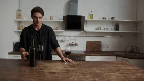 Young couple drinks wine in the kitchen. celebrates anniversary, promotion at Stock Footage 117297092