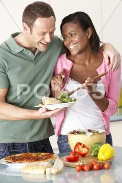 Young Couple Eating Meal In Kitchen Stock Photos