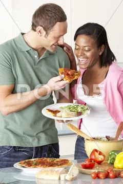 Young Couple Eating Meal In Kitchen Stock-Fotos