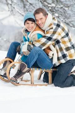 Young couple embracing on sled Stock Photos