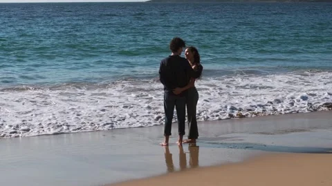 Young Couple Embracing While Standing On Sandy Beach Stock Footage 310955147