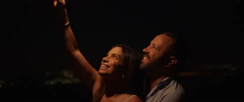 Young couple enjoy celebrating, while holding a firework at night Stock Footage 136240599