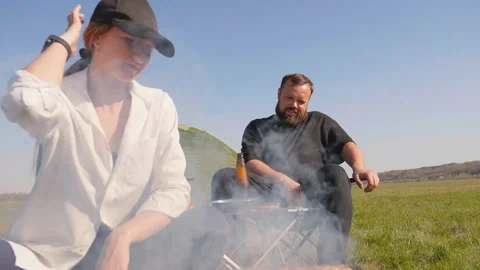 Young couple enjoying a barbecue picnic in nature while camping 库存影片 344606953