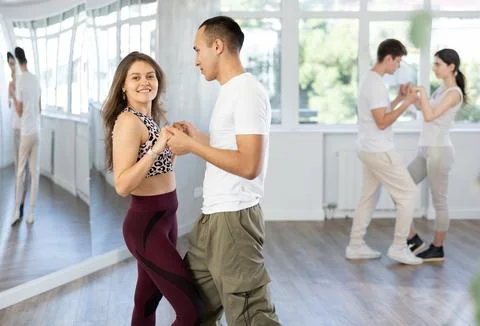 Young couple enjoying impassioned merengue in latin dance class Stock Photos