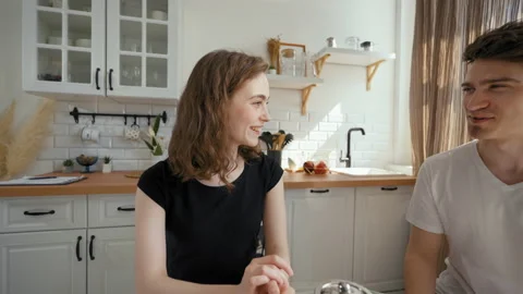 Young couple enjoys drinking tea sitting at kitchen table Stock Footage 201186719