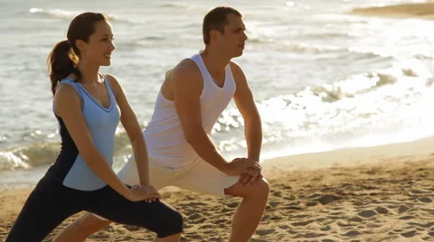 Young couple exercising on the beach Stock Footage 43620092