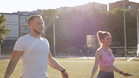 Young couple exercising outdoors at sunset - jumping with skipping rope. Stock Footage 158565386