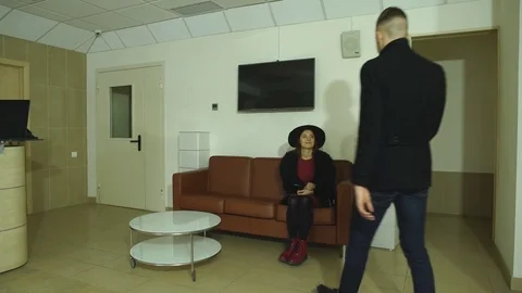 A young couple exits the hotel through the reception Stock Footage