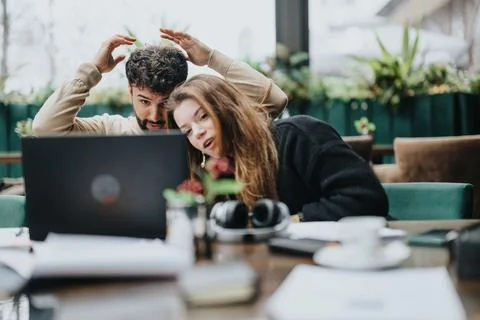 A young couple experiences surprise while viewing content on a laptop in a cozy Stock Photos