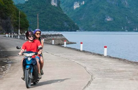 Young couple exploring Cat Ba Island on a motor scooter Stockfoto's