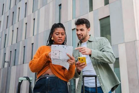 Young couple exploring city while navigating map and smartphone for directions 스톡 사진