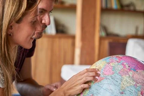 Young couple exploring world globe Stockfoto's