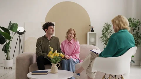 Young couple feeling relieved after therapy, shaking hands with counselor Stock Footage 331360531