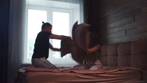 Young Funny Couple In Underwear Fighting With Pillows In The Bed