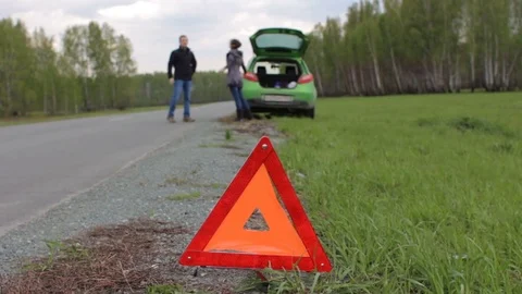 Young couple fighting on the road in forest. Car breakdown, red triangle Stock Footage 75920283