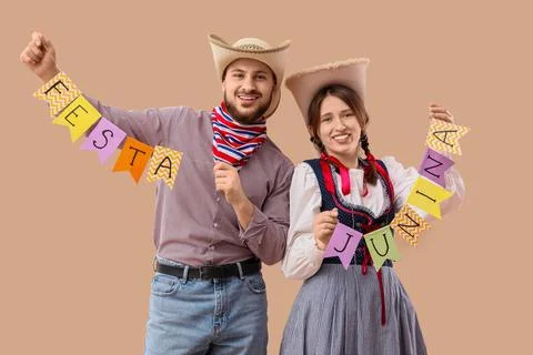Young couple with flags on beige background. Festa Junina (June Festival) cel Stock Photos