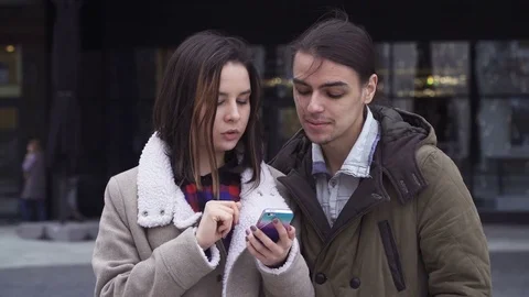 Young couple flipping the screen of a smartphone Stock Footage 74393548