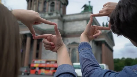 Young couple framing with fingers while walking in a city center. Tourist Video stock 119220534