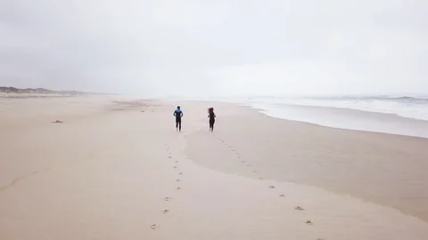 Young couple of friendly surfers wearing wetsuit Stock Footage
