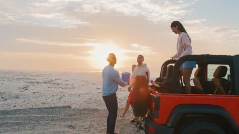 Young Couple With Friends Unloading Cool Box From Car At Beach At Sunrise Vídeo Stock 273086282
