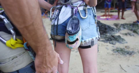 Young couple getting ready to climb, chalking hands, preparing to climb mountain Stock Footage 201096725