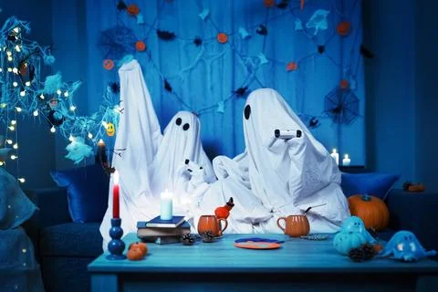 Young couple in ghost costumes having Halloween fun at home. Spending a spo.. Stock Photos