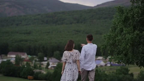 A young couple go and cuddle, cuddle against the background of large mountains Stock Footage 137094188