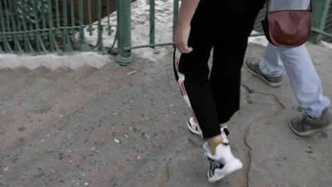 Young couple goes down old stairs walking on cloudy day Stock Footage 138636995