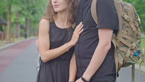A young couple, a guy with a camouflage backpack and a girl stand on the Stock Footage 157525272