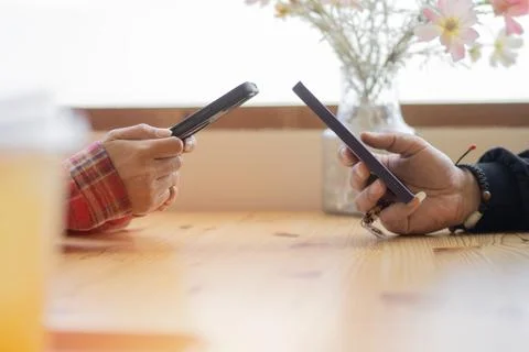 Young couple hands using two phones share social media or talking doing sho.. Stock Photos