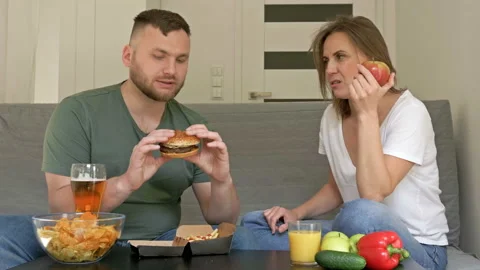 Young couple has different eating habits. The husband is happy to eat fast food Video stock 130813184