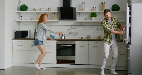 Young couple has fun in kitchen, dancing and entertaining Stock Footage 114897519