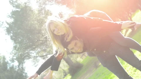Young couple has fun in park - backlit. Stock Footage 45126390