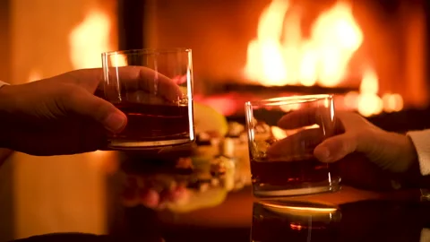 Young couple has romantic dinner with whiskey over fireplace background. Stock Footage 166394222