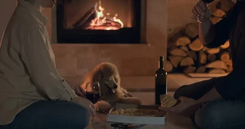 Young couple have romantic dinner with pizza and wine over fireplace background. Stock Footage 100413407
