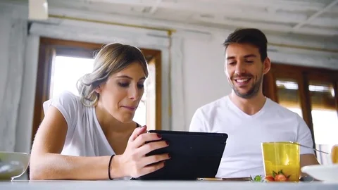 Young couple having breakfast and watching tablet together Stock Footage 74727839