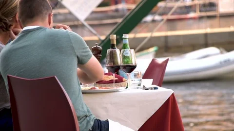 Young couple having dinner and drinking wine by the glass at restaurant's table Stock Footage 96248573