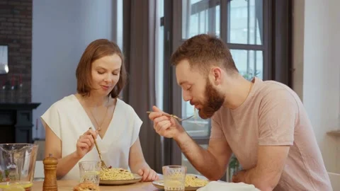 Young couple having dinner eating pasta at home Stock Footage 146278224