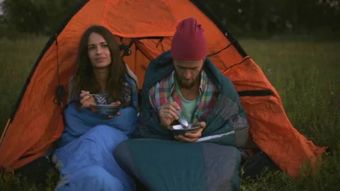 Young couple having dinner in the evening while sitting in a tent. 스톡 동영상 116521256