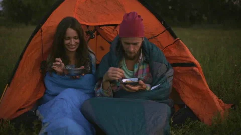 Young couple having dinner in the evening while sitting in a tent. Stock-Footage 116550770