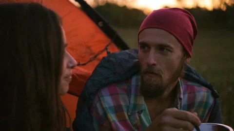 Young couple having dinner in the evening while sitting in a tent. Stock-Footage 116556958