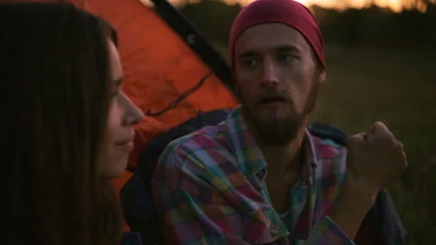 Young couple having dinner in the evening while sitting in a tent. Vídeo Stock 116557163