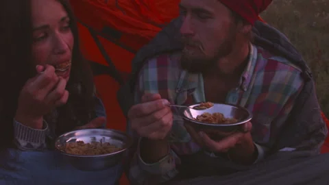 Young couple having dinner in the evening while sitting in a tent. 스톡 동영상 116928754