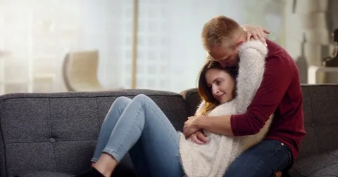 Young couple having fun and cuddling on the couch Stock Footage 78038530